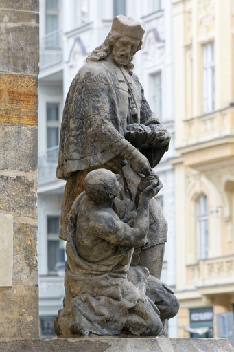 Sv. Jan Nepomucký jako almužník, asi 1725, Praha (ul. Dušní) – Autor: Gampe, licence CC BY-SA 4.0, https://commons.wikimedia.org/wiki/File:Statue_of_John_of_Nepomuk_in_Du%C5%A1n%C3%AD,_Prague_(4310).jpg
